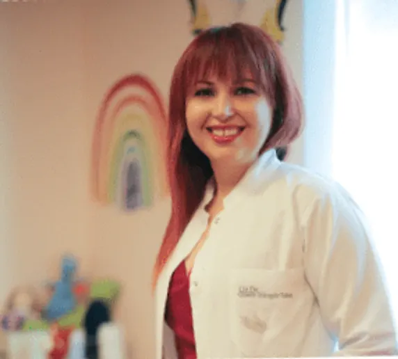 Uzm. Dr. Gizem Güngör Takeş kliniğinde, beyaz önlüğüyle gülümsüyor